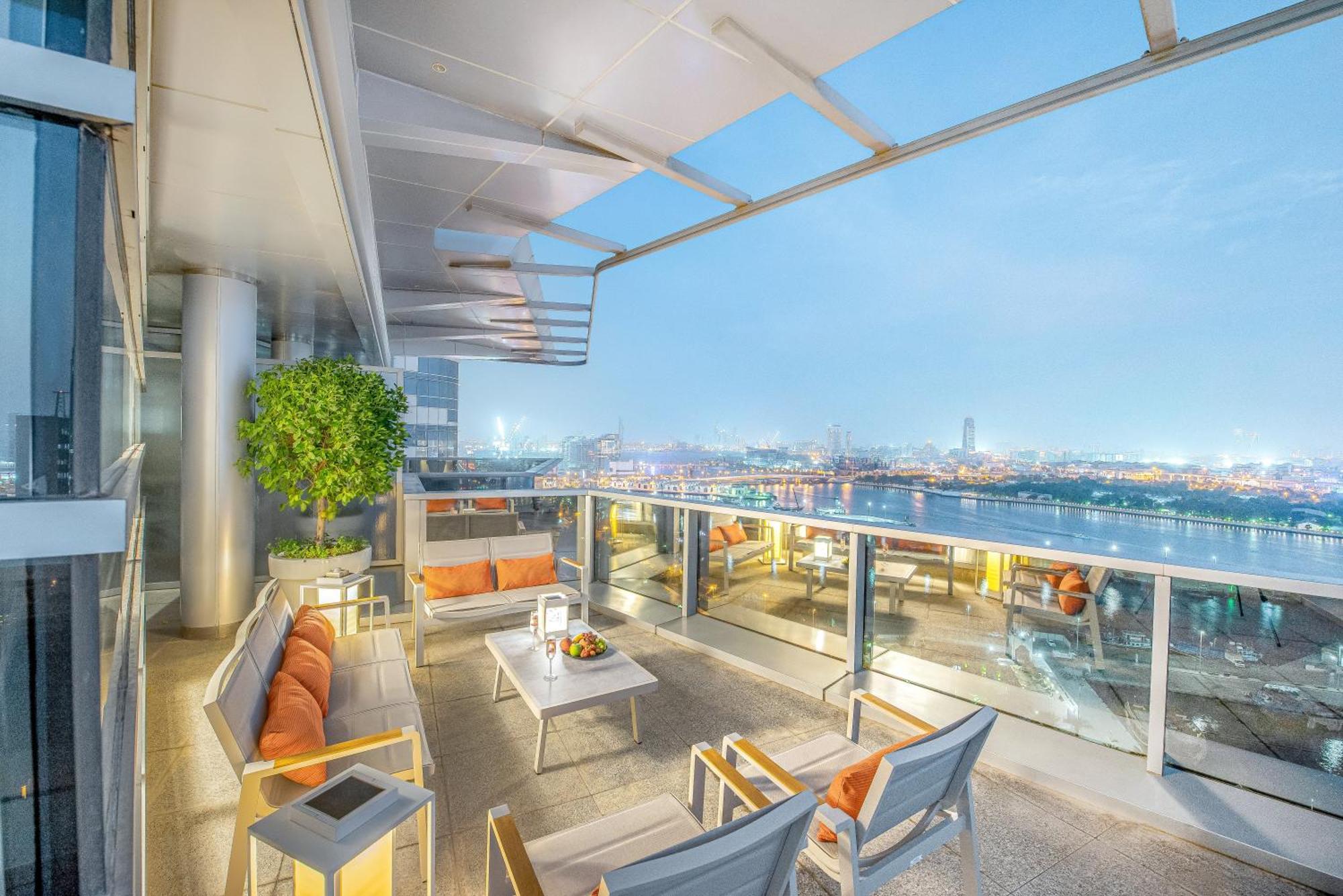 Golden Sands Boutique Hotel-Dubai Creek Екстериор снимка The photo depicts a stylish balcony space with a modern design. It features outdoor seating consisting of several chairs and a table, all arranged to provide a comfortable area for relaxation. The seating has soft cushions in warm colors, and the tab