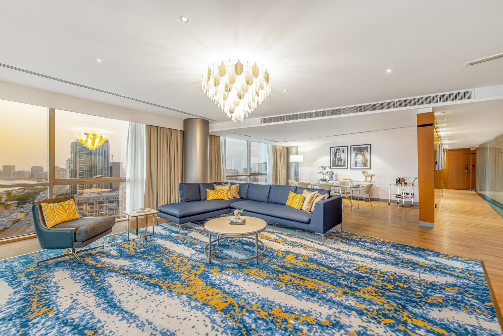 Golden Sands Boutique Hotel-Dubai Creek Екстериор снимка The photo shows a modern and stylish living room interior. It features a spacious layout with large windows allowing natural light to fill the space. The flooring is covered with a decorative area rug that displays a vibrant design in blue and yellow