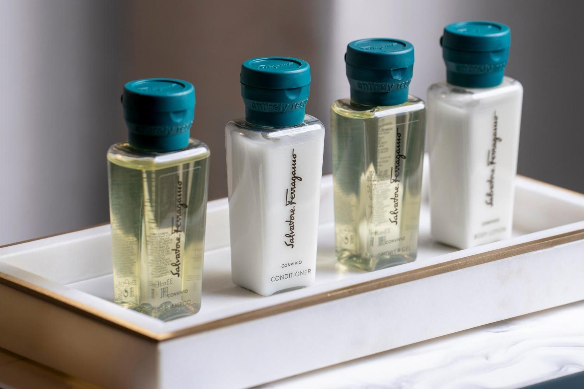 Golden Sands Boutique Hotel-Dubai Creek Екстериор снимка The photo shows a set of four small, elegant bottles displayed on a white tray. Each bottle has a teal cap and a simple, stylish design. The bottles contain different products, likely for personal care or grooming, with some holding transparent liqui